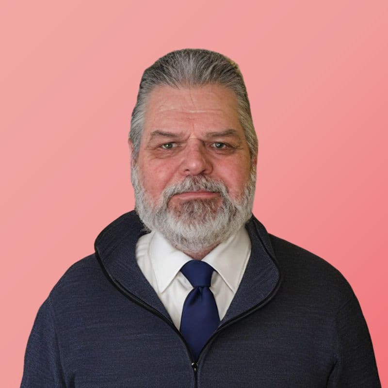 Mitch Williams in a dark zip-up sweater, shirt, and tie