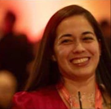 Smiling attendee in a warmly lit convention ballroom