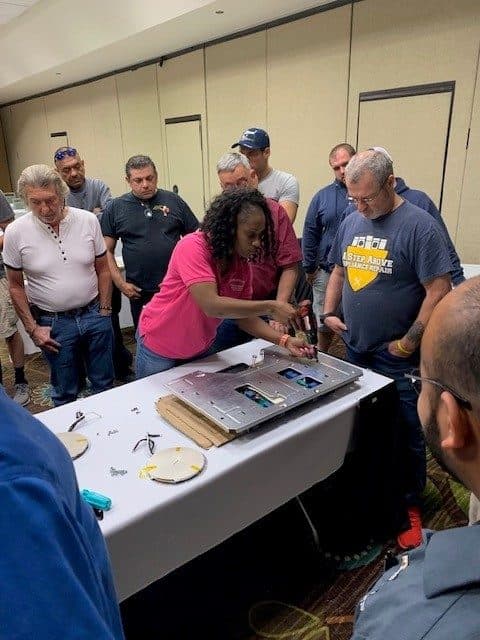 Technician leading a hands-on appliance teardown demo